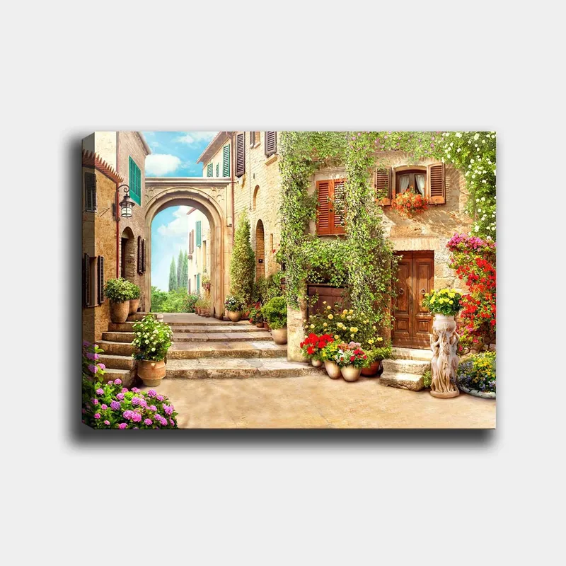 Lerretsbilde 70x100 cm - Malerisk gate med blomster og grøntområder i sjarmerende landsbymiljø, Grønn / Gul / Rosa