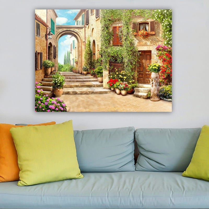 Lerretsbilde 70x100 cm - Malerisk gate med blomster og grøntområder i sjarmerende landsbymiljø - Grønn / Gul / Rosa - Innredning - Bilder & kunst - Lerretsbilder