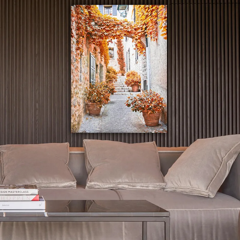 Lerretsbilde 70x100 cm - Malerisk smug omgitt av fargerike høstblader og potteplanter - Oransje / Brun / Gul - Innredning - Bilder & kunst - Lerretsbilder