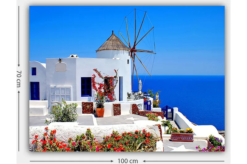 Lerretsbilde 70x100 cm - Malerisk utsikt over en hvitkalket bygning med en tradisjonell vindmølle og fargerike blomster på Santorini - Hvit / Blå / Rød - Innredning - Bilder & kunst - Lerretsbilder