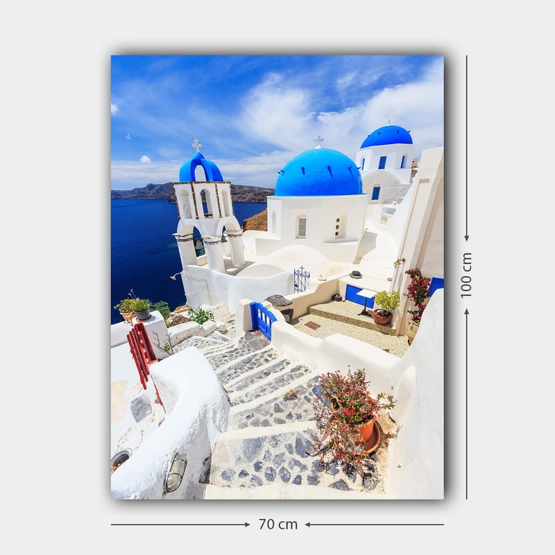 Lerretsbilde 70x100 cm - Malerisk utsikt over hvite hus med blå kupler og en asfaltert vei i en gresk øy-setting - Blå / Hvit - Innredning - Bilder & kunst - Lerretsbilder