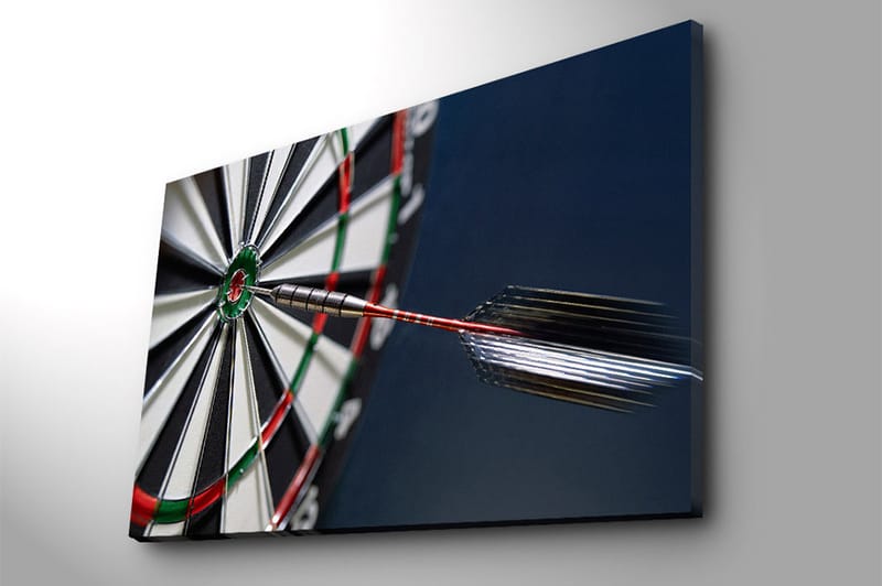 Lerretsbilde 70x100 cm - Nærbilde av en dartskive med en pil som treffer midtpunktet - Grønn / Rød / Svart - Innredning - Bilder & kunst - Lerretsbilder