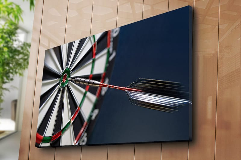 Lerretsbilde 70x100 cm - Nærbilde av en dartskive med en pil som treffer midtpunktet - Grønn / Rød / Svart - Innredning - Bilder & kunst - Lerretsbilder