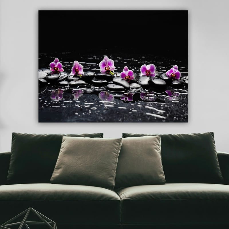 Lerretsbilde 70x100 cm - Rad med lilla orkideer som hviler på svarte steiner med refleksjoner i vann - Lilla / Svart - Innredning - Bilder & kunst - Lerretsbilder