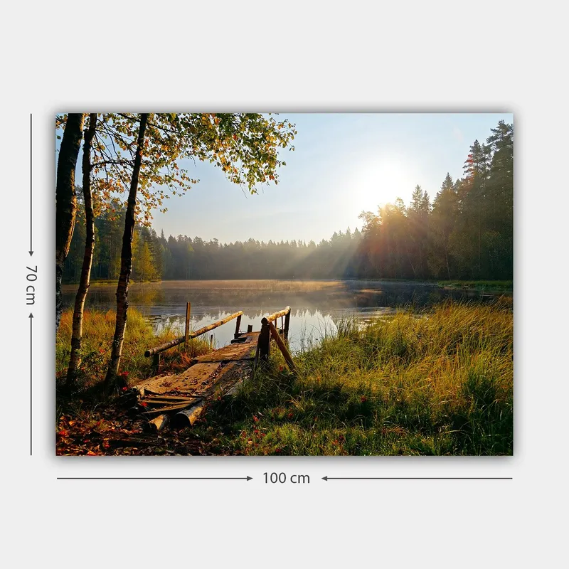Lerretsbilde 70x100 cm - Rolig innsjø med en trebro omgitt av frodige trær og morgensolens stråler - Grønn / Brun / Gul - Innredning - Bilder & kunst - Lerretsbilder