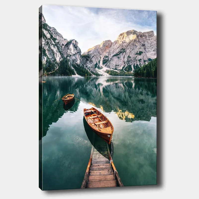 Lerretsbilde 70x100 cm - Rolig innsjø med to trebåter omgitt av majestetiske fjell og frodig skog, Grønn / Brun / Blå