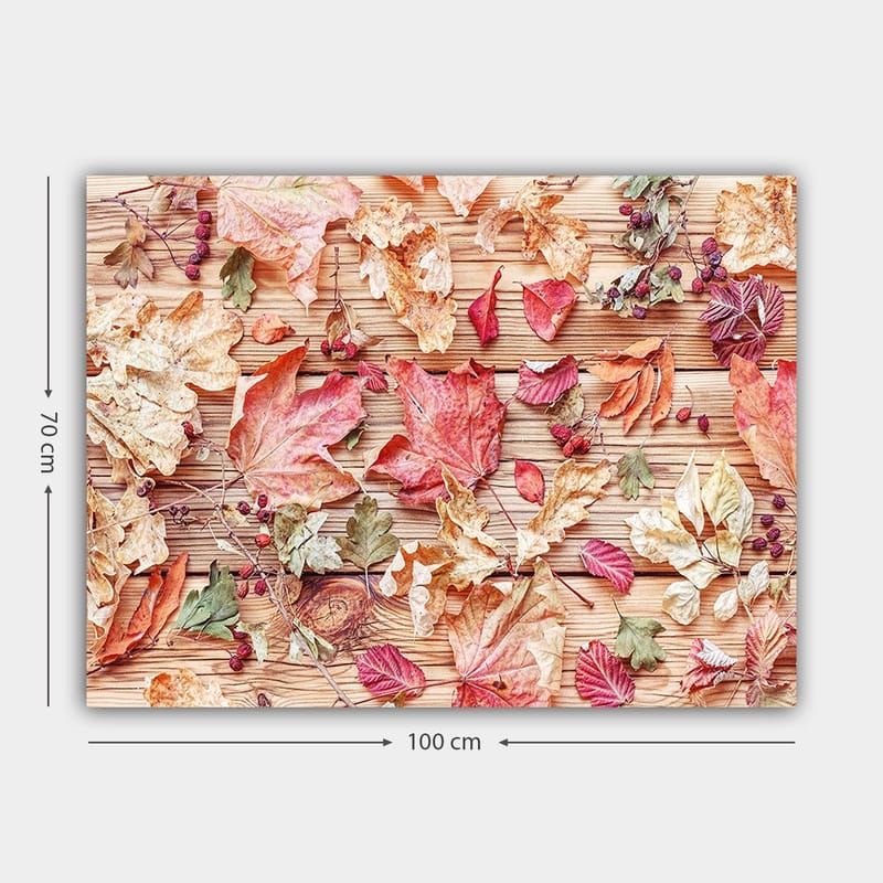 Lerretsbilde 70x100 cm - Samling av høstblader i forskjellige farger som ligger på en treflate - Rød / Gul / Grønn - Innredning - Bilder & kunst - Lerretsbilder