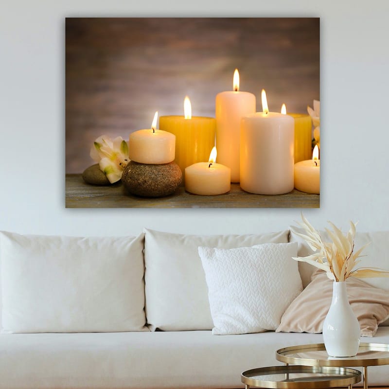 Lerretsbilde 70x100 cm - Samling av tente lys i forskjellige former og størrelser, omgitt av steiner og en blomst - Gul / Hvit / Beige - Innredning - Bilder & kunst - Lerretsbilder