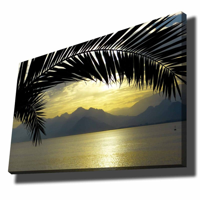 Lerretsbilde 70x100 cm - Silhuett av palmer mot en gyllen solnedgang over fjellene og havet, Svart / Gull / Grå