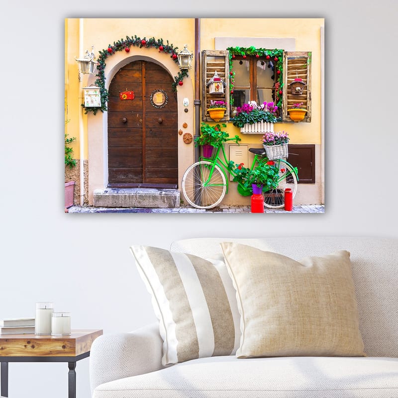 Lerretsbilde 70x100 cm - Sjarmerende dør med blomster og en sykkel i et fargerikt miljø, Grønn / Brun / Rød