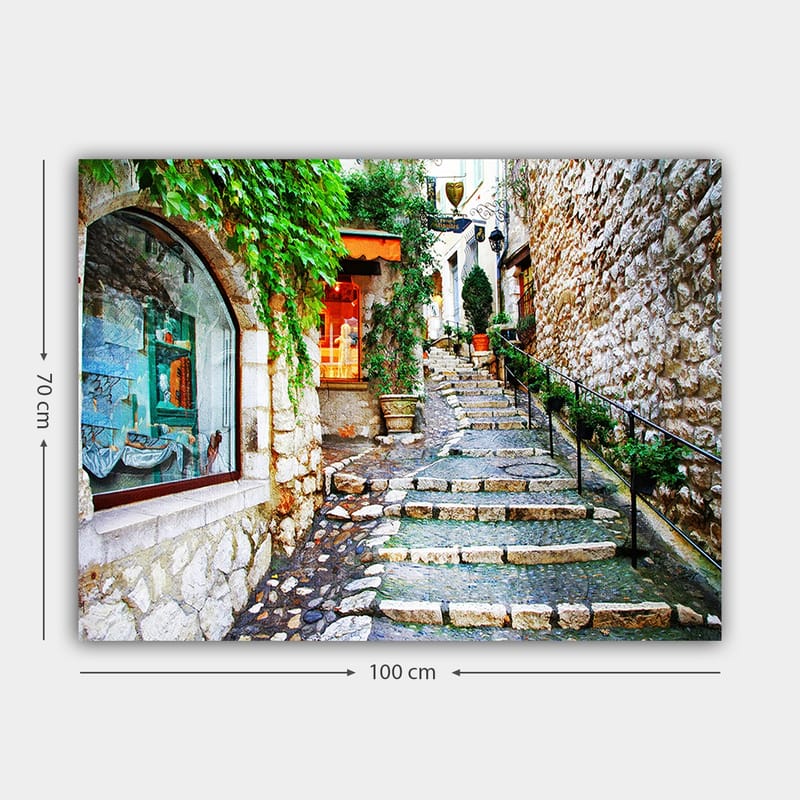 Lerretsbilde 70x100 cm - Sjarmerende smug med steiner og grøntområder som fører oppover, omgitt av historiske bygninger - Grønn / Beige / Oransje - Innredning - Bilder & kunst - Lerretsbilder