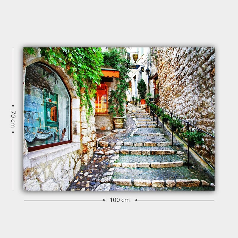 Lerretsbilde 70x100 cm - Sjarmerende smug med steiner og grøntområder som fører oppover, omgitt av historiske bygninger - Grønn / Beige / Oransje - Innredning - Bilder & kunst - Lerretsbilder