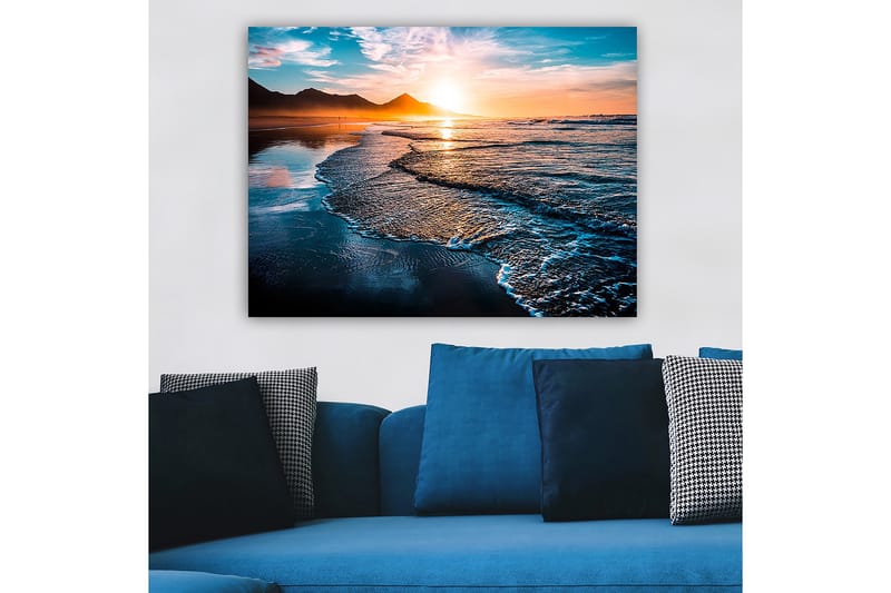 Lerretsbilde 70x100 cm - Solnedgang over en strand med milde bølger som ruller inn mot kysten - Blå / Oransje / Turkis - Innredning - Bilder & kunst - Lerretsbilder