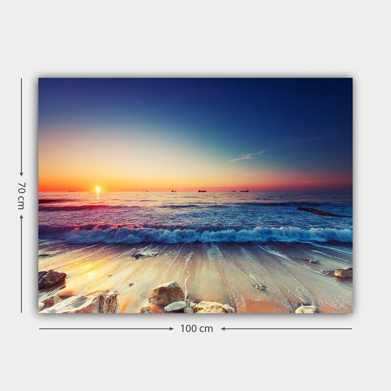 Lerretsbilde 70x100 cm - Solnedgang over havet med myke bølger som ruller inn mot kysten - Blå / Oransje / Rosa - Innredning - Bilder & kunst - Lerretsbilder