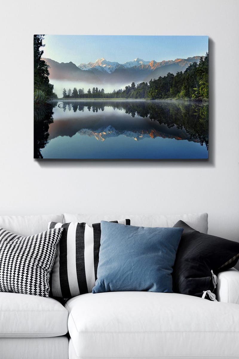 Lerretsbilde 70x100 cm - Speilbilde av majestetiske fjell speilet i en rolig innsjø omgitt av frodig skog - Blå / Grønn / Hvit - Innredning - Bilder & kunst - Lerretsbilder