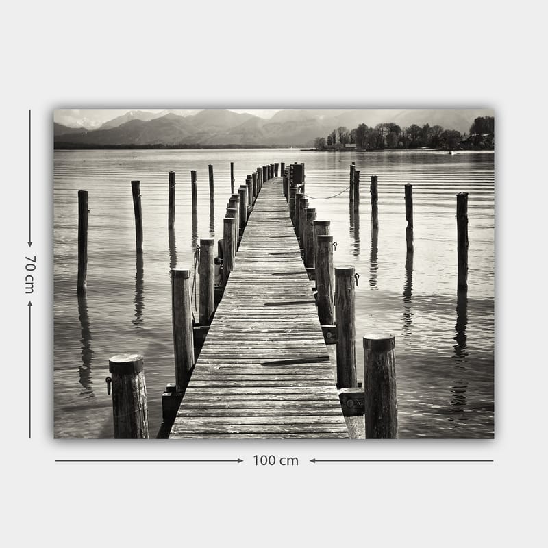Lerretsbilde 70x100 cm - Stille brygge som strekker seg ut over vannet, omgitt av søyler som speiler seg i overflaten - Svart / Hvit / Grå - Innredning - Bilder & kunst - Lerretsbilder