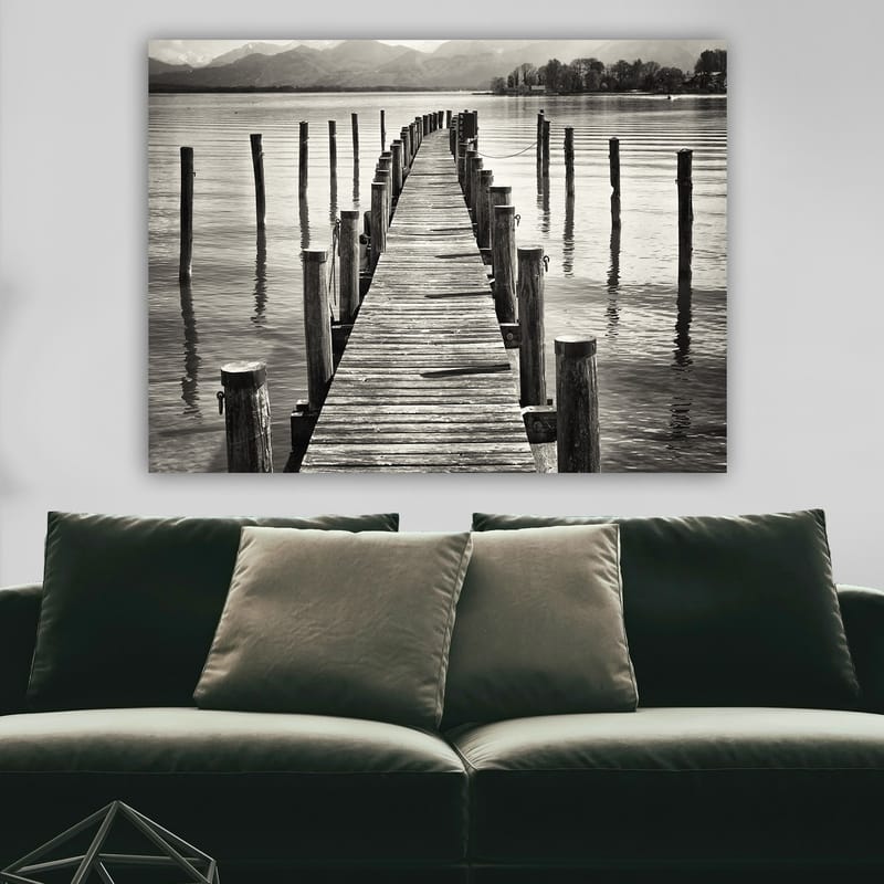 Lerretsbilde 70x100 cm - Stille brygge som strekker seg ut over vannet, omgitt av søyler som speiler seg i overflaten - Svart / Hvit / Grå - Innredning - Bilder & kunst - Lerretsbilder