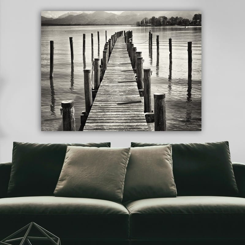 Lerretsbilde 70x100 cm - Stille brygge som strekker seg ut over vannet, omgitt av søyler som speiler seg i overflaten - Svart / Hvit / Grå - Innredning - Bilder & kunst - Lerretsbilder