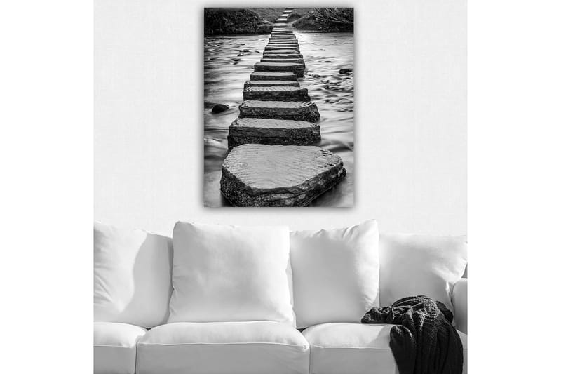 Lerretsbilde 70x100 cm - Svart-hvitt-bilde av steiner som danner en sti over vannoverflaten, Svart / Hvit / Grå