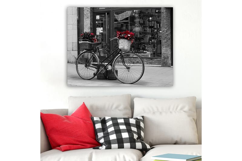 Lerretsbilde 70x100 cm - Svart sykkel med blomster i kurver på en gate, Rød / Svart / Grå