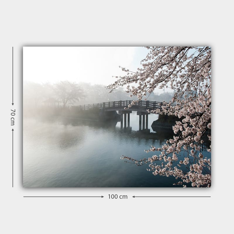 Lerretsbilde 70x100 cm - Tåkete landskap med en bro som går over en stille innsjø, omgitt av blomstrende kirsebærtrær - Lys rosa / Blå / Grå - Innredning - Bilder & kunst - Lerretsbilder