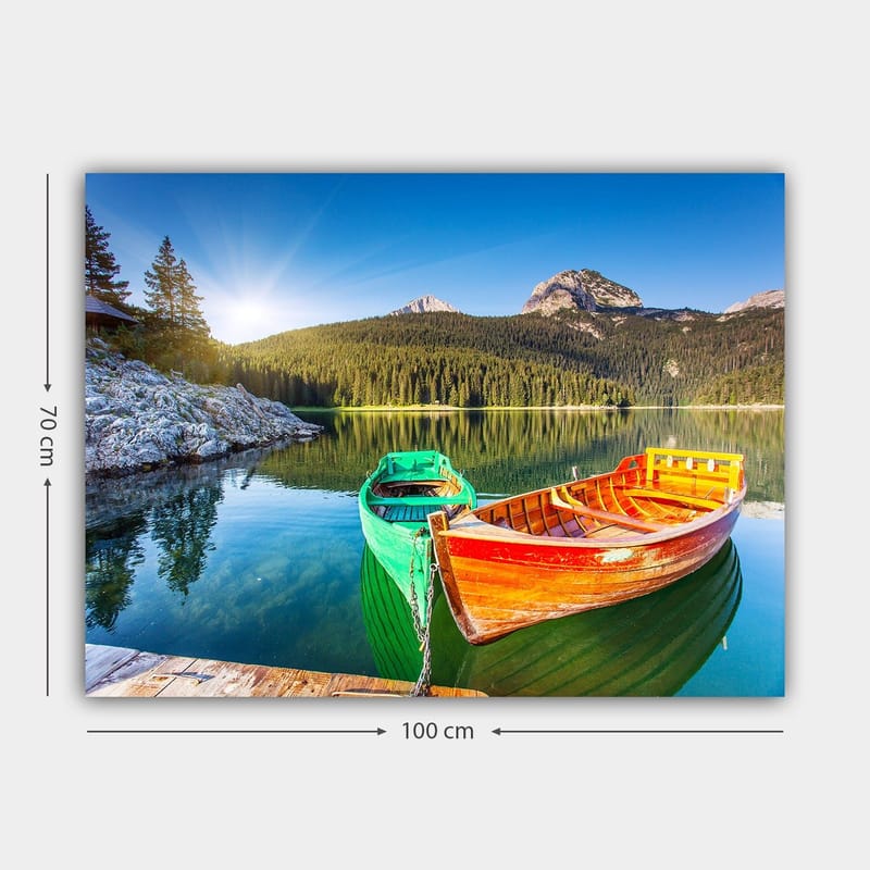 Lerretsbilde 70x100 cm - To fargerike båter ligger stille på en speilblank innsjø omgitt av frodige fjell - Grønn / Oransje / Blå - Innredning - Bilder & kunst - Lerretsbilder