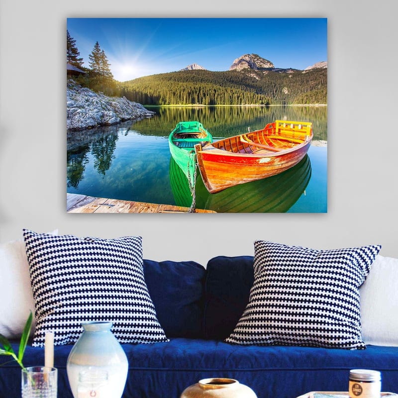 Lerretsbilde 70x100 cm - To fargerike båter ligger stille på en speilblank innsjø omgitt av frodige fjell - Grønn / Oransje / Blå - Innredning - Bilder & kunst - Lerretsbilder