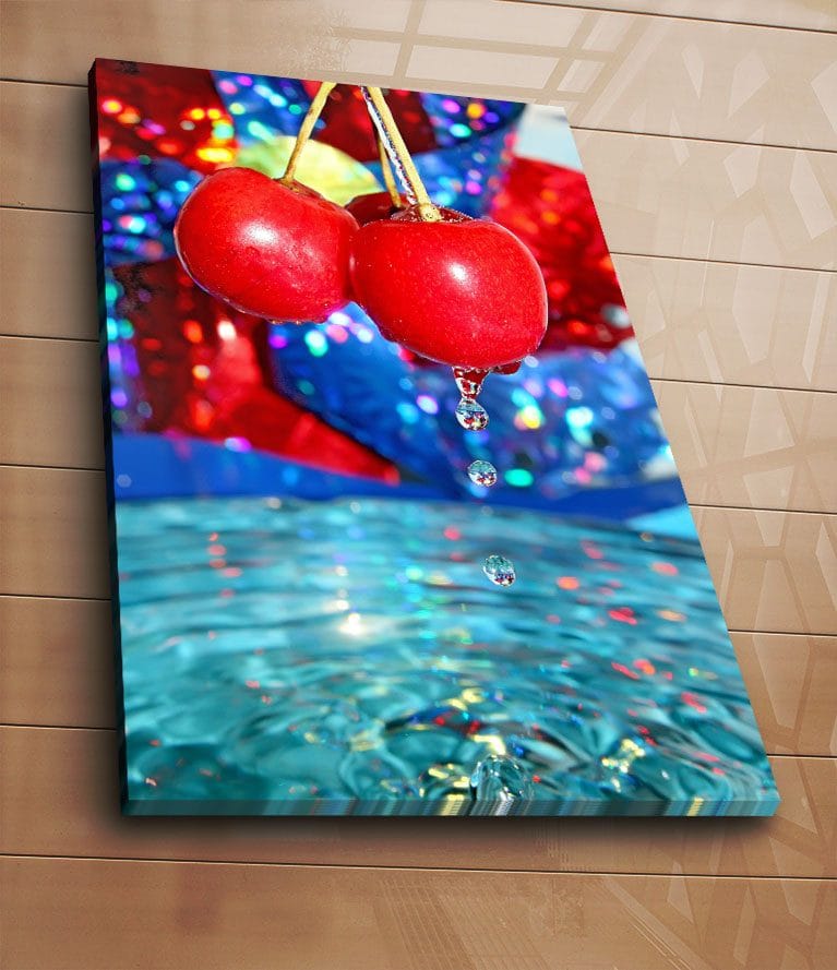 Lerretsbilde 70x100 cm - To røde kirsebær som henger over en vannflate med dråper som faller ned - Rød / Blå / Turkis - Innredning - Bilder & kunst - Lerretsbilder