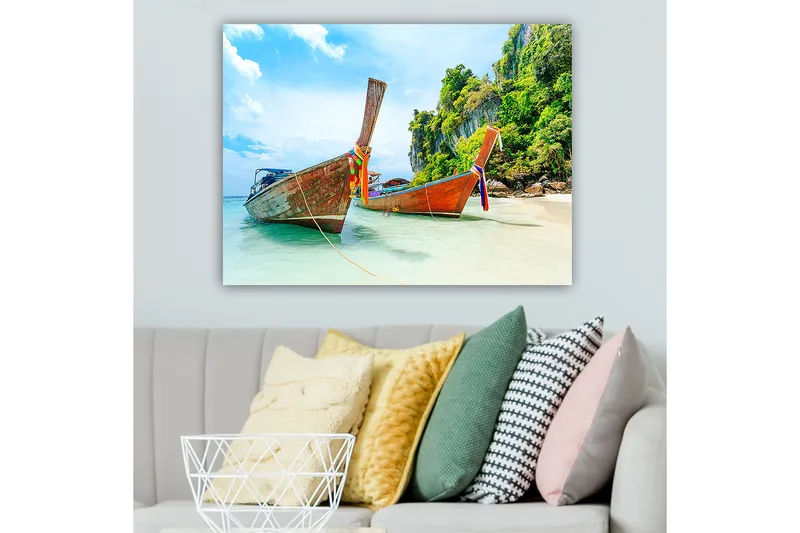 Lerretsbilde 70x100 cm - To tradisjonelle thailandske langbåter på en strand med steiner og frodig vegetasjon i bakgrunnen - Brun / Grønn / Blå - Innredning - Bilder & kunst - Lerretsbilder