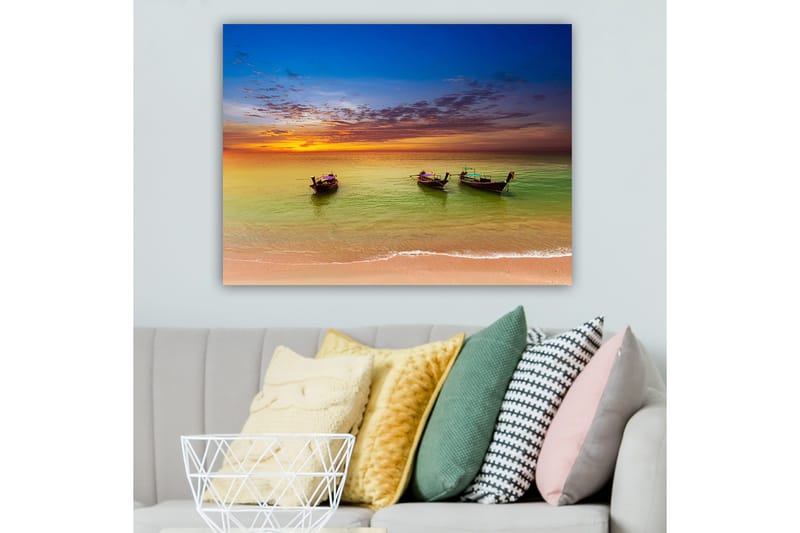 Lerretsbilde 70x100 cm - Tre tradisjonelle båter som ligger på en strand under en fargerik solnedgang, Blå / Oransje / Grønn