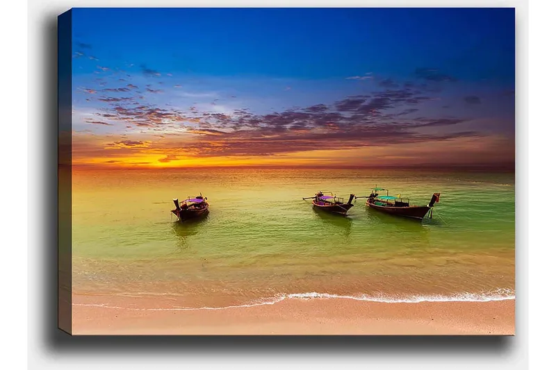 Lerretsbilde 70x100 cm - Tre tradisjonelle båter som ligger på en strand under en fargerik solnedgang - Blå / Oransje / Grønn - Innredning - Bilder & kunst - Lerretsbilder