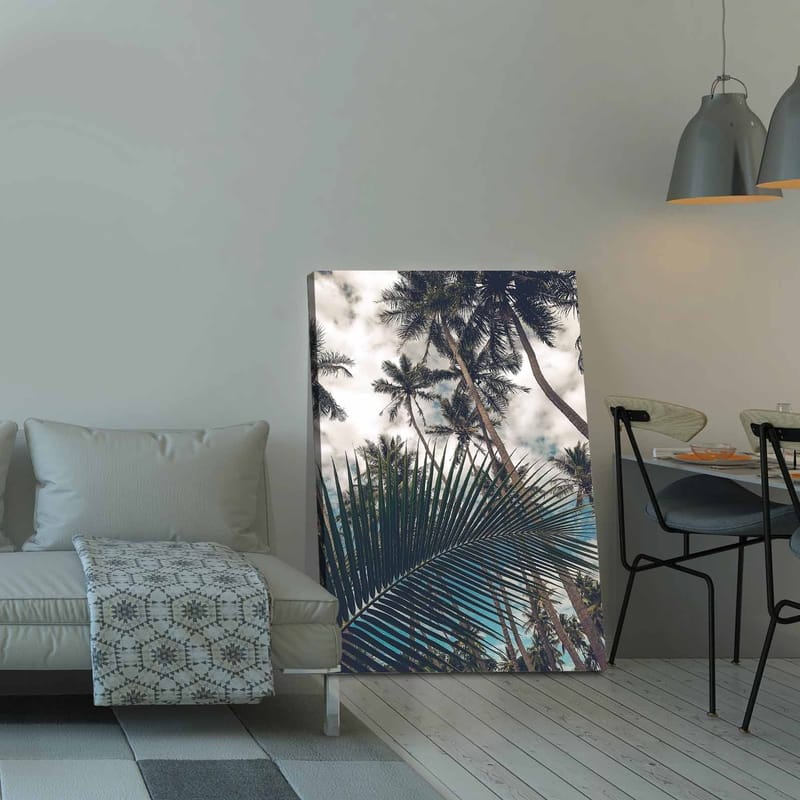 Lerretsbilde 70x100 cm - Tropisk palmelund med et stort palmeblad i forgrunnen - Mørkegrønn / Lysegrønn / Blå - Innredning - Bilder & kunst - Lerretsbilder
