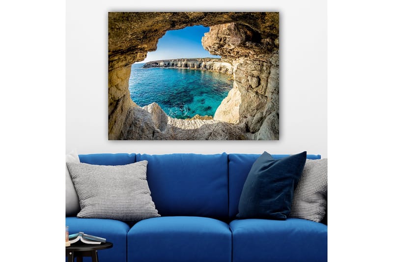 Lerretsbilde 70x100 cm - Utsikt gjennom en klippeåpning mot en klar blå strand - Blå / Beige / Hvit - Innredning - Bilder & kunst - Lerretsbilder