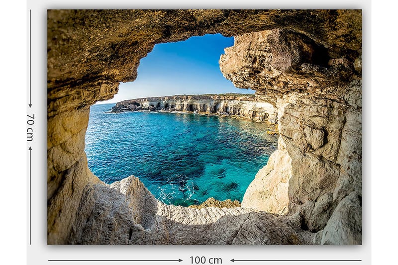 Lerretsbilde 70x100 cm - Utsikt gjennom en klippeåpning mot en klar blå strand - Blå / Beige / Hvit - Innredning - Bilder & kunst - Lerretsbilder