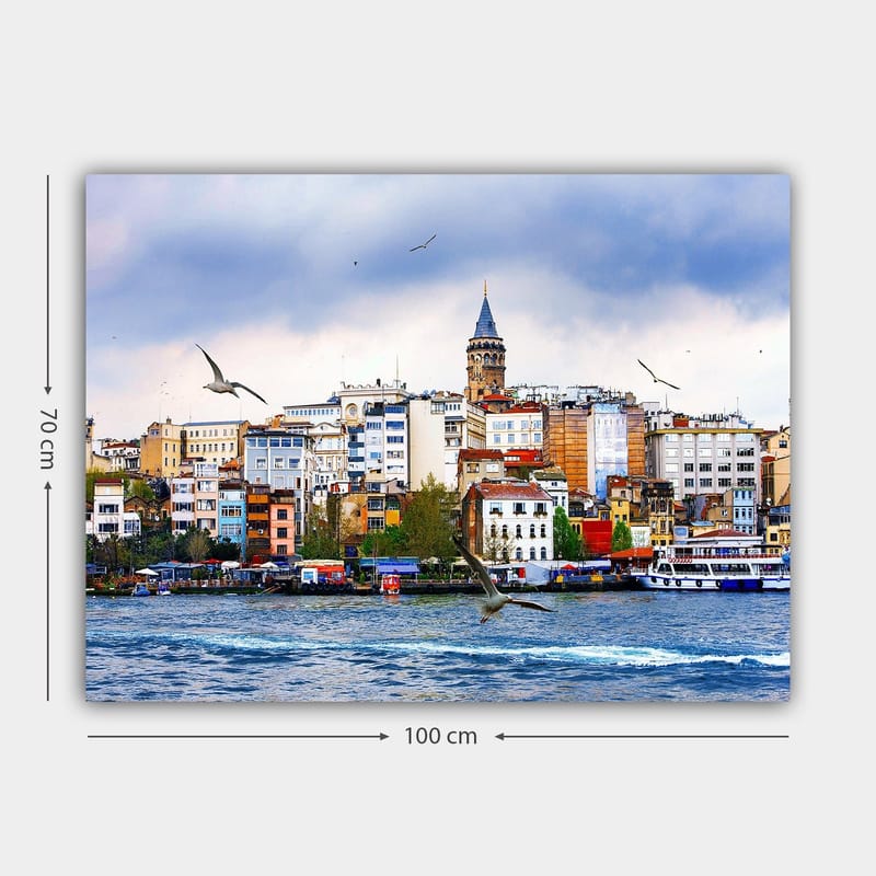 Lerretsbilde 70x100 cm - Utsikt over en by med et historisk klokketårn og fugler som svever over vannet - Blå / Hvit / Beige - Innredning - Bilder & kunst - Lerretsbilder