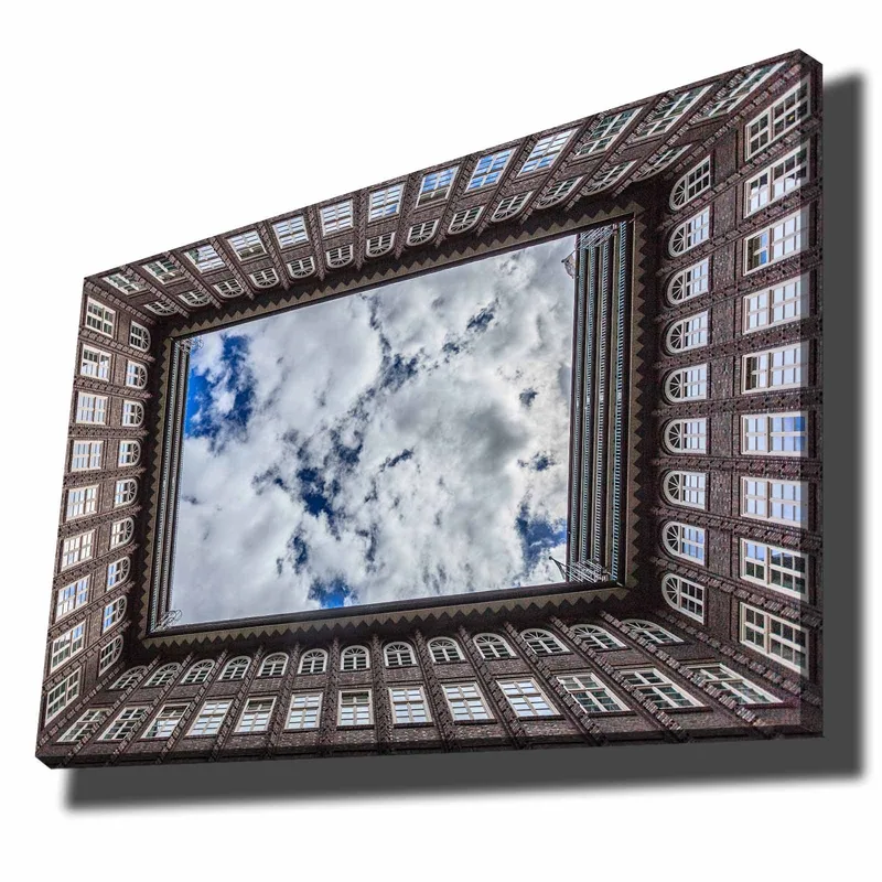 Lerretsbilde 70x100 cm - Utsikt over en bygningsfasade som rammer inn et speilbilde av himmelen, Mørk brun / Hvit / Lys blå
