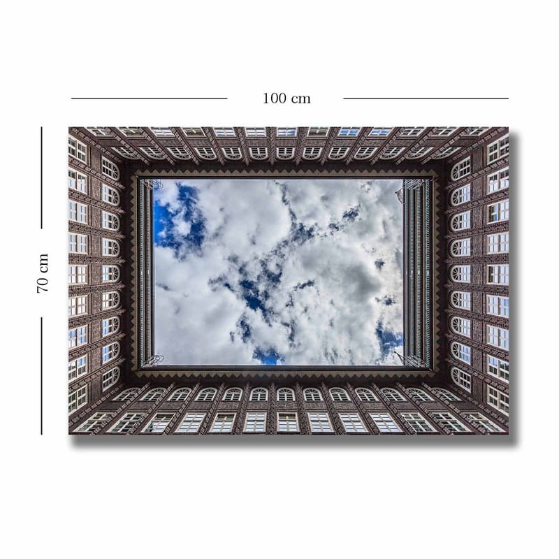 Lerretsbilde 70x100 cm - Utsikt over en bygningsfasade som rammer inn et speilbilde av himmelen - Mørk brun / Hvit / Lys blå - Innredning - Bilder & kunst - Lerretsbilder