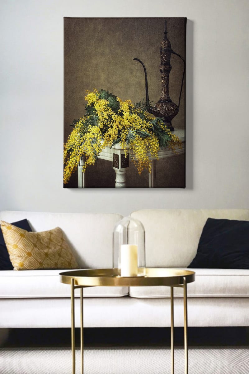 Lerretsbilde 70x100 cm - Vakker bukett med mimosablomster i gult, plassert på et bord ved siden av en elegant, mørkebrun mugge - Gul / Mørkegrønn / Brun - Innredning - Bilder & kunst - Lerretsbilder