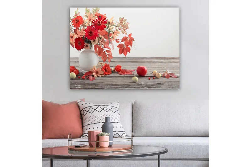 Lerretsbilde 70x100 cm - Vakker bukett med røde og oransje blomster i en hvit vase, omgitt av høstblader og frukt - Rød / Oransje / Grønn - Innredning - Bilder & kunst - Lerretsbilder