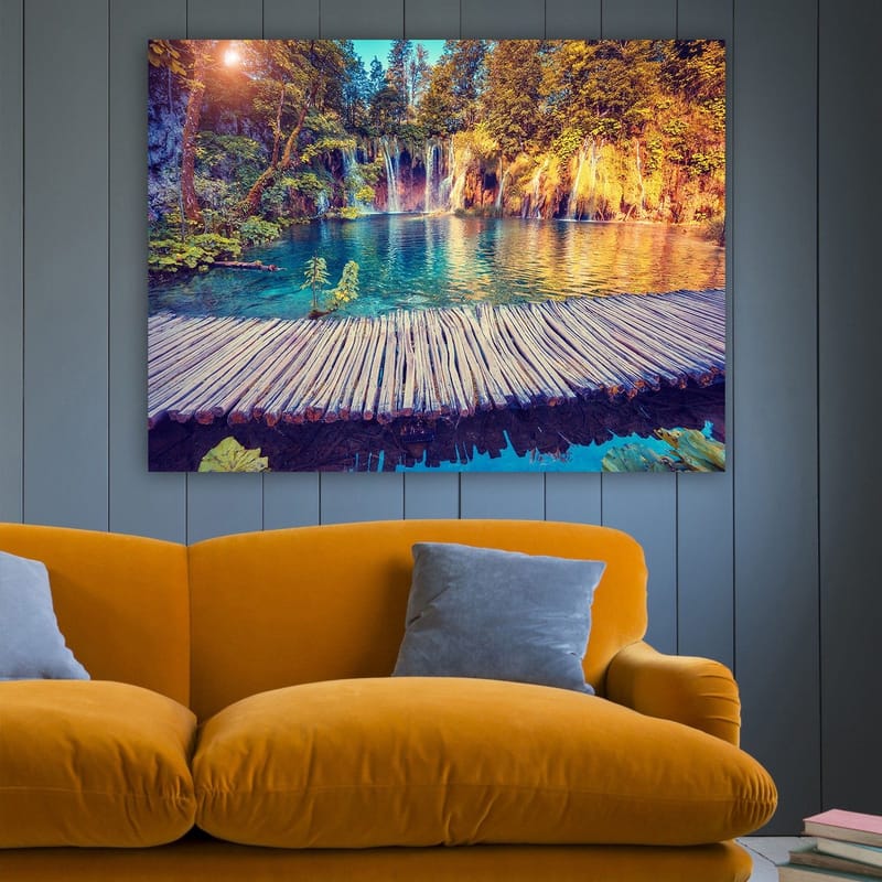 Lerretsbilde 70x100 cm - Vakker foss med klart blått vann omgitt av frodig grøntområde og trær - Blå / Grønn / Brun - Innredning - Bilder & kunst - Lerretsbilder