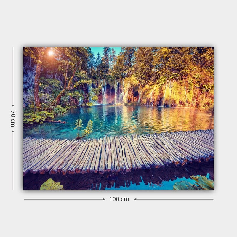 Lerretsbilde 70x100 cm - Vakker foss med klart blått vann omgitt av frodig grøntområde og trær - Blå / Grønn / Brun - Innredning - Bilder & kunst - Lerretsbilder