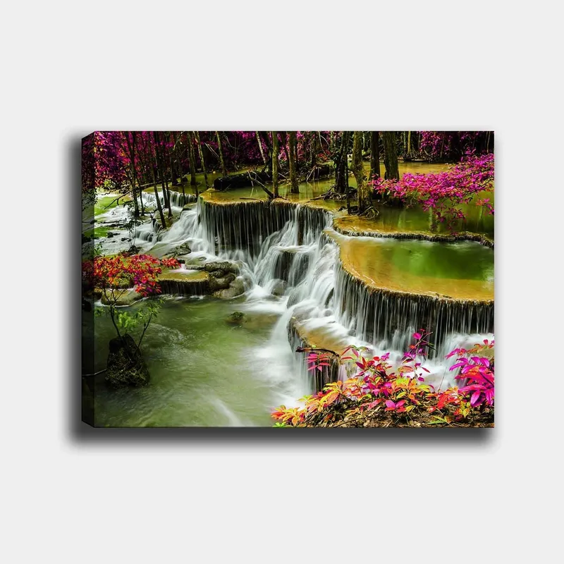 Lerretsbilde 70x100 cm - Vakker foss omgitt av fargerike blomster og frodige trær, Grønn / Rosa / Brun