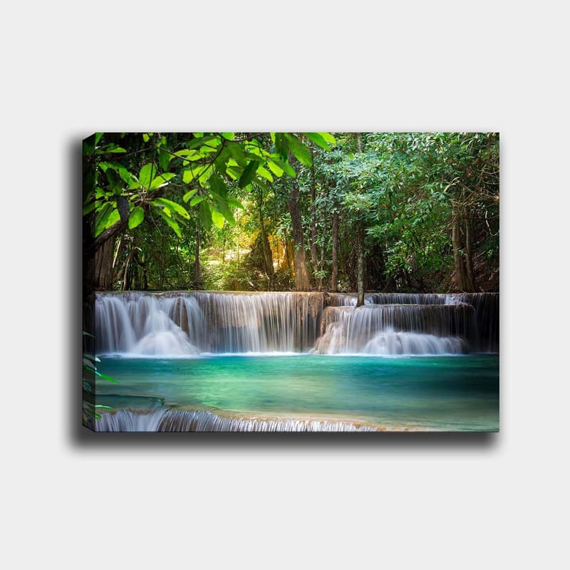 Lerretsbilde 70x100 cm - Vakker foss omgitt av frodig grøntområde, Grønn / Turkis / Brun