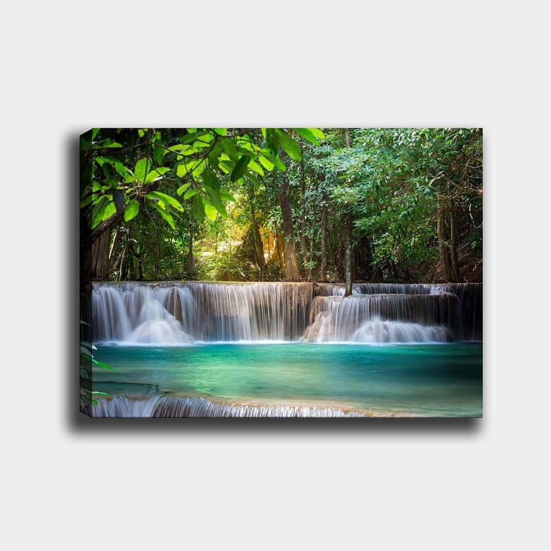 Lerretsbilde 70x100 cm - Vakker foss omgitt av frodig grøntområde, Grønn / Turkis / Brun