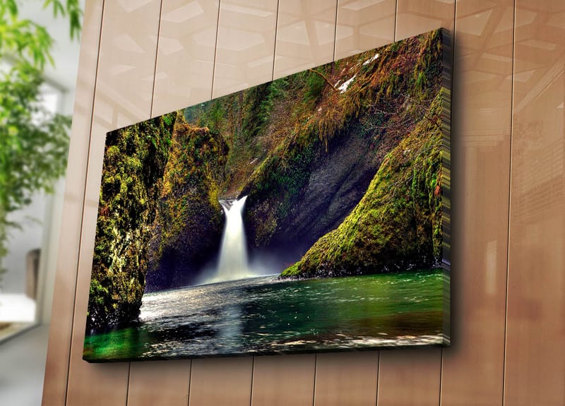 Lerretsbilde 70x100 cm - Vakker foss som renner ned mellom grønne klipper i naturskjønne omgivelser - Grønn / Blå / Brun - Innredning - Bilder & kunst - Lerretsbilder