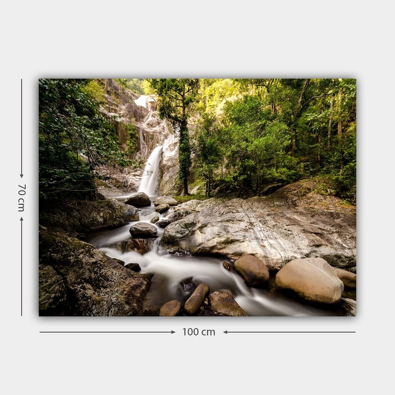 Lerretsbilde 70x100 cm - Vakker fossescene omgitt av frodig grøntområde og steinblokker - Grønn / Grå / Brun - Innredning - Bilder & kunst - Lerretsbilder