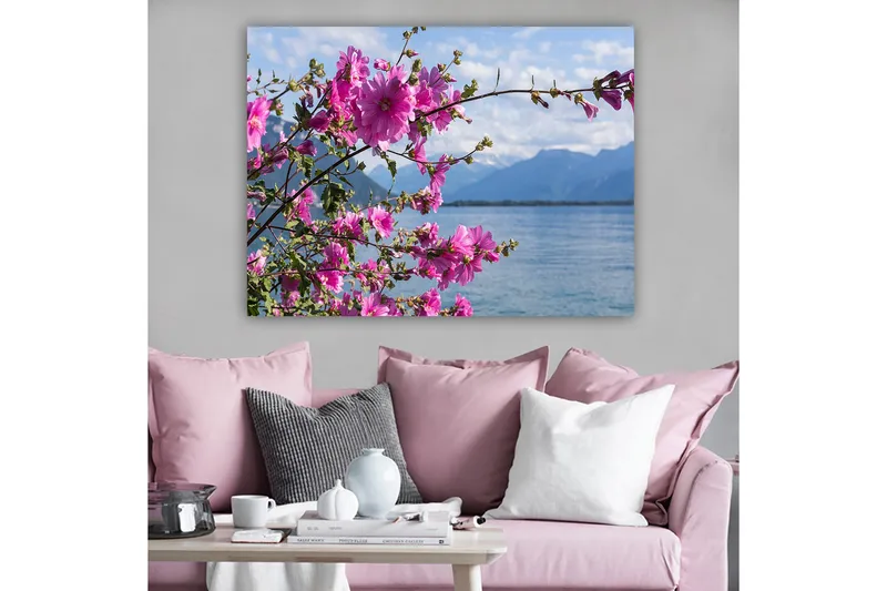 Lerretsbilde 70x100 cm - Vakker gruppe blomster som strekker seg over en innsjø med fjell i bakgrunnen - Rosa / Grønn - Innredning - Bilder & kunst - Lerretsbilder