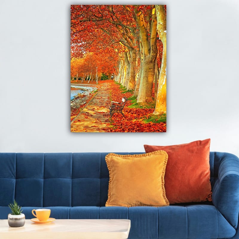 Lerretsbilde 70x100 cm - Vakker høstscene med en benk langs en allé med trær med glitrende røde og oransje blader - Rød / Oransje / Gul - Innredning - Bilder & kunst - Lerretsbilder