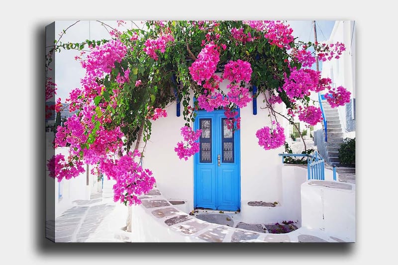 Lerretsbilde 70x100 cm - Vakker hvit bygning med en blå dør omgitt av lilla blomster - Lilla / Blå / Grønn - Innredning - Bilder & kunst - Lerretsbilder