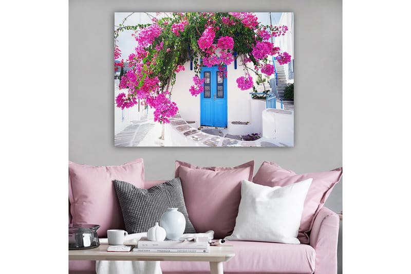 Lerretsbilde 70x100 cm - Vakker hvit bygning med en blå dør omgitt av lilla blomster - Lilla / Blå / Grønn - Innredning - Bilder & kunst - Lerretsbilder